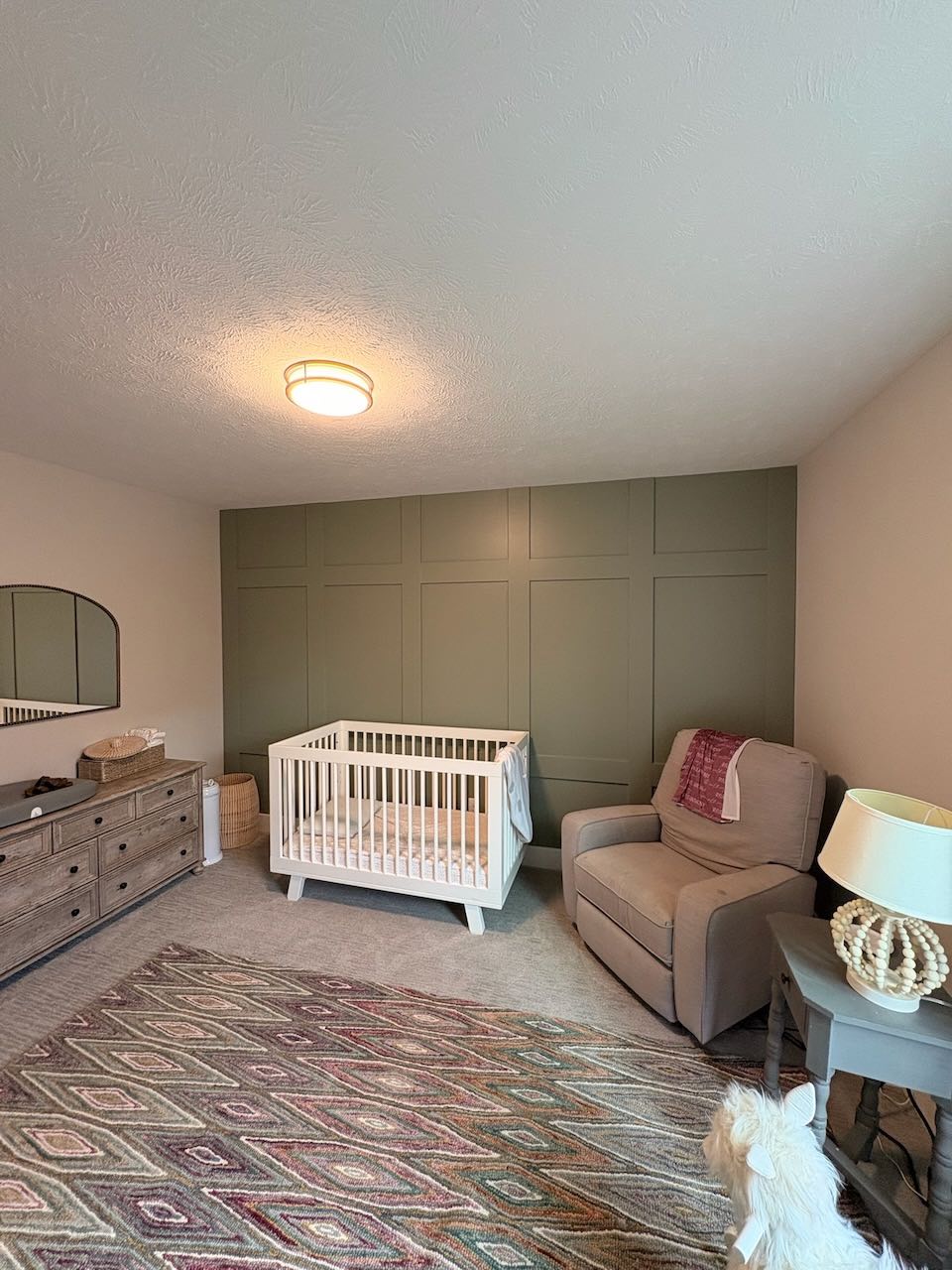 Nursery with painted olive accent wall